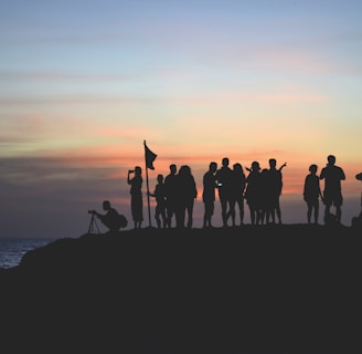 silhouette photography of people gathered together on cliff