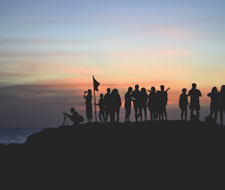 silhouette photography of people gathered together on cliff