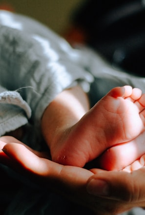 person holding baby feet