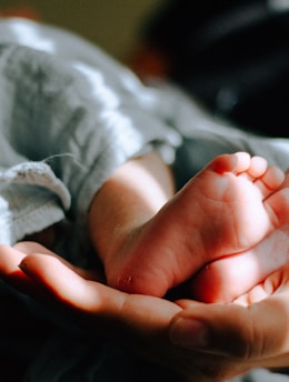 person holding baby feet