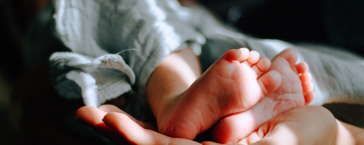 person holding baby feet