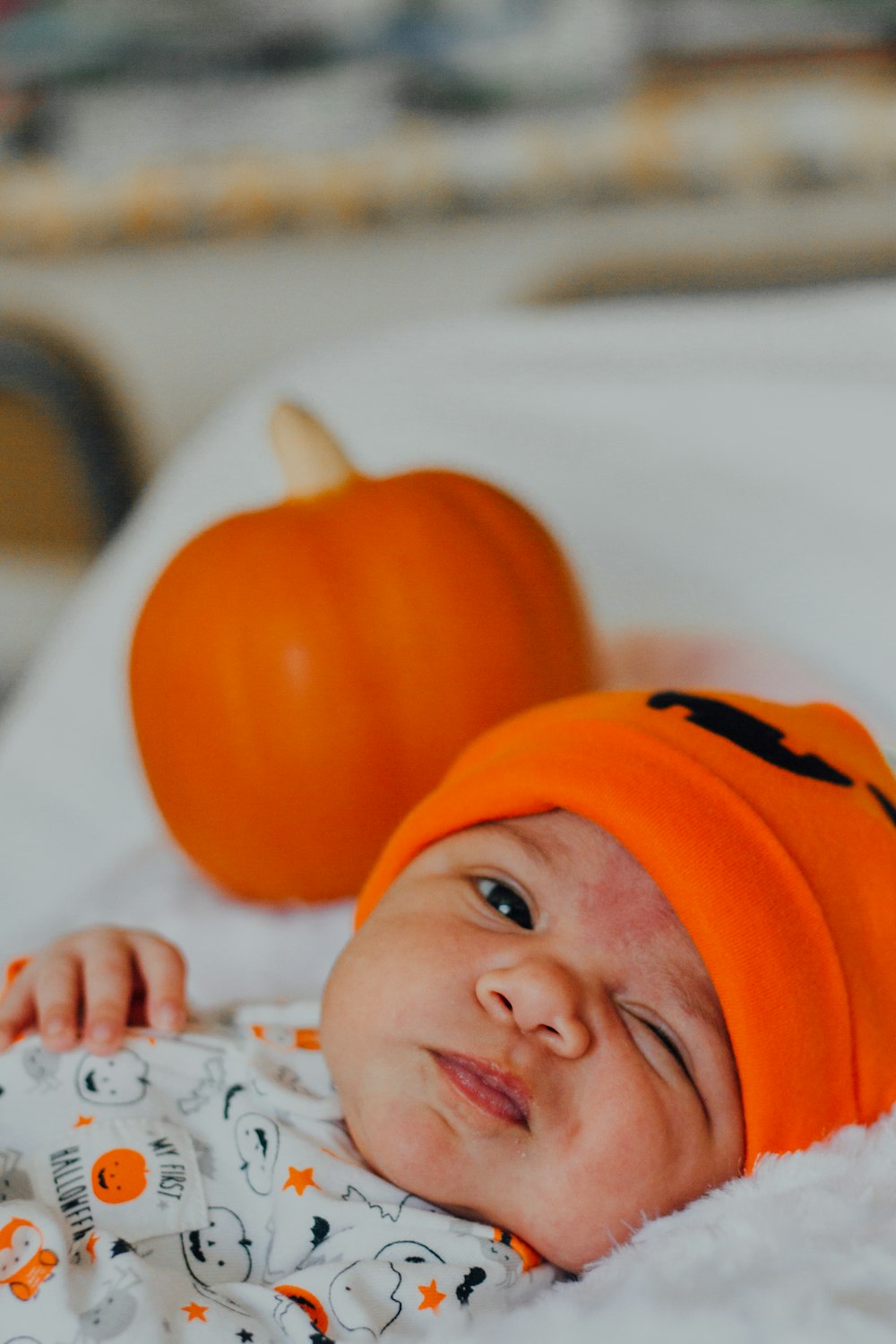オレンジ色のニット帽をかぶった赤ちゃん