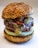 Close-up of a delicious burger with fresh toppings on a wooden table.