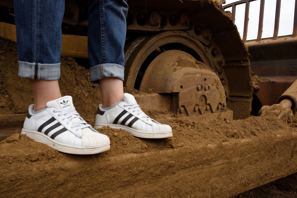 person wearing blue denim jeans and white adidas sneakers photo – Free  Caterpilar Image on Unsplash