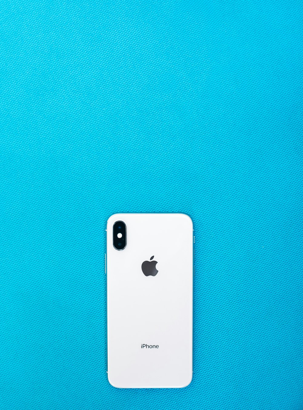post-2017 iPhone on teal surface