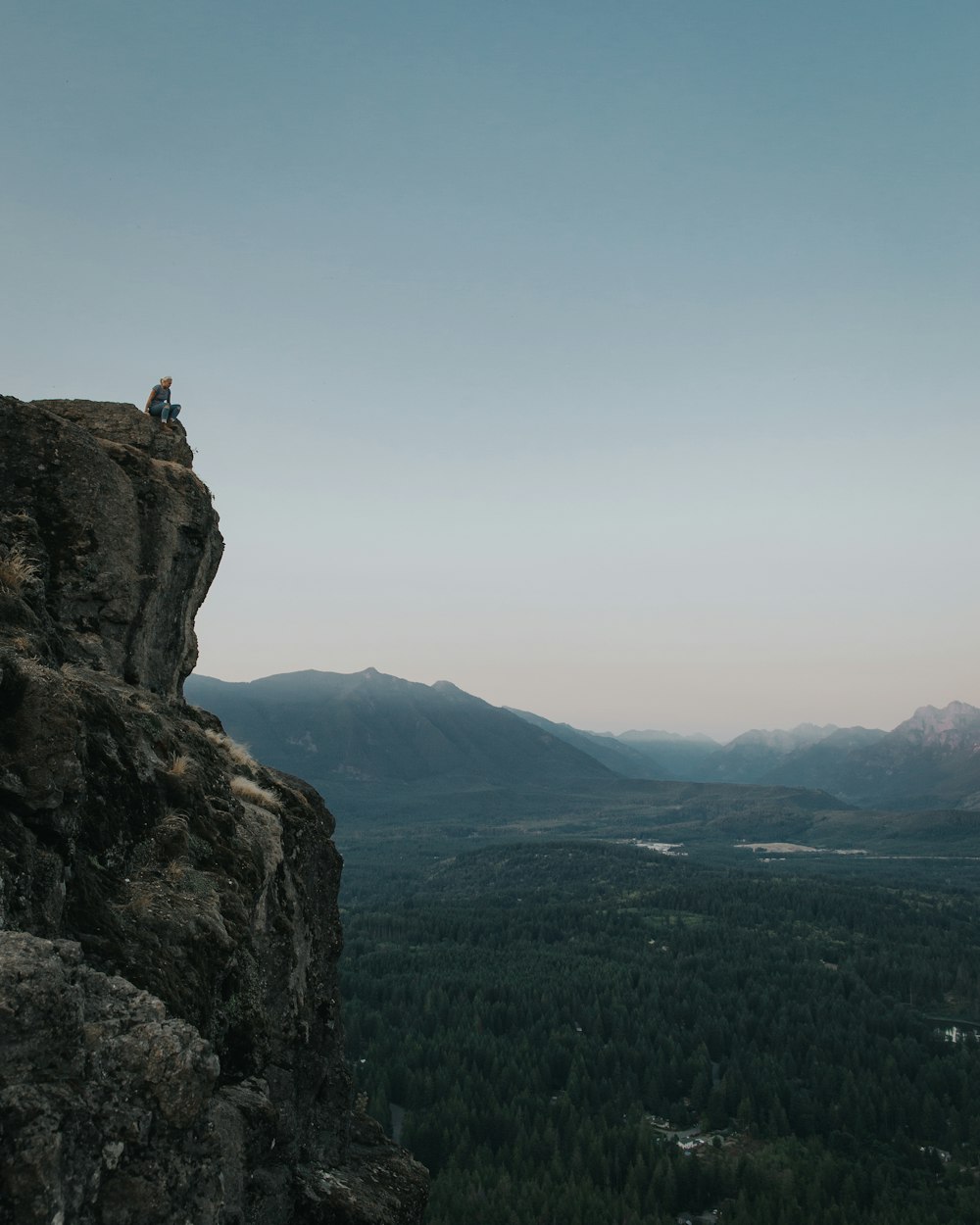 person sitting on rock formation during daytime