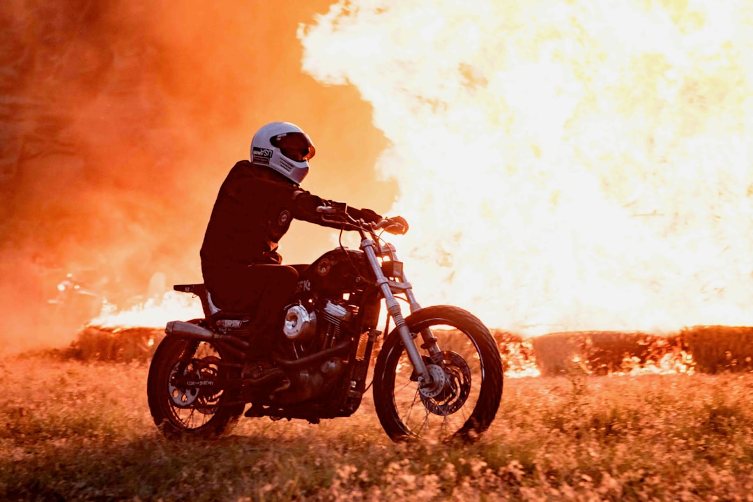 person riding motorcycle near burning structure
