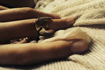Close-up of a handcrafted silver ring resting on a white textured fabric.