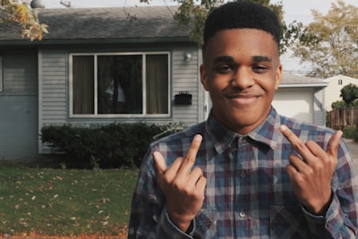 A real estate agent handing keys to a happy client in front of a house.