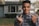 A smiling homeowner shaking hands with a real estate investor outdoors.