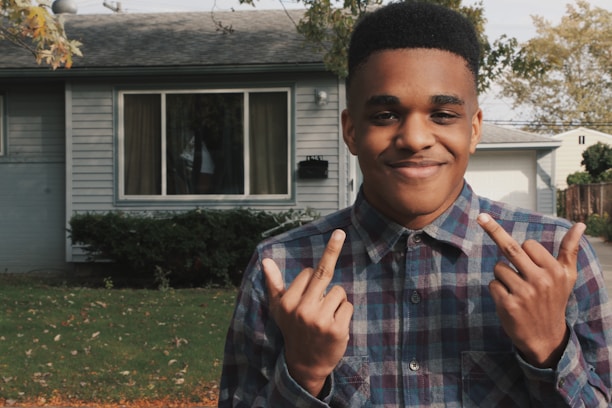 A satisfied customer shaking hands with a plumber in front of a house.
