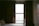 A cozy bedroom with dark blackout curtains softly filtering morning light.
