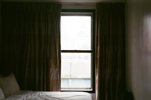 Peaceful bedroom setting with soft lighting and a window framing the surrounding Ardennes forest.