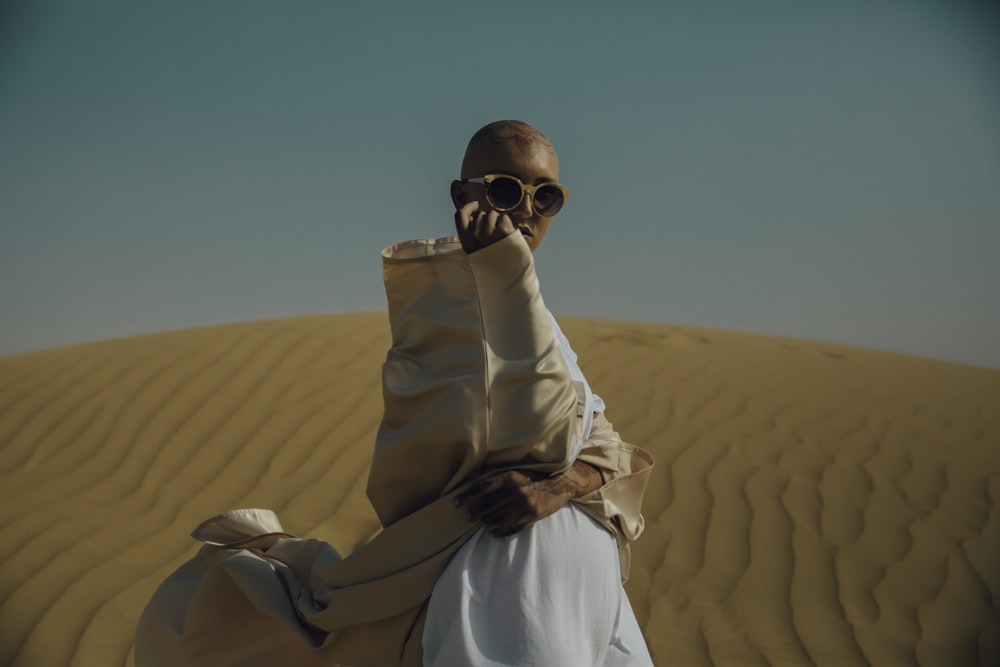 man in brown and white apparel on desert during daytime