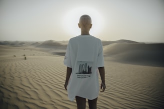photography of bald woman standing on desert
