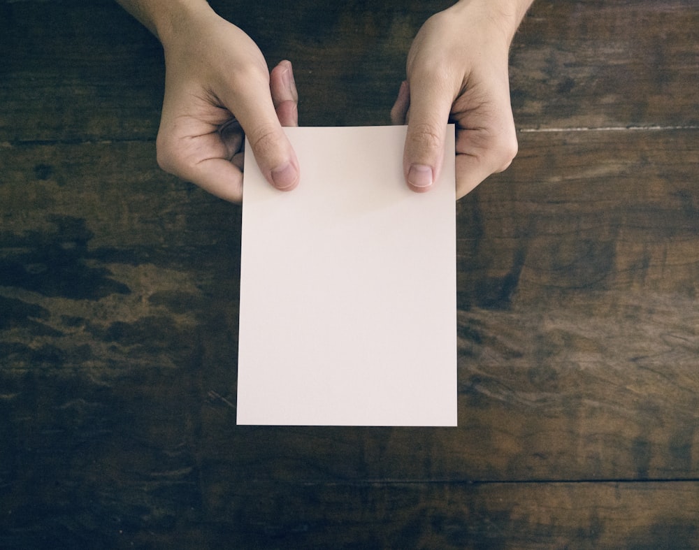 person holding white printer paper