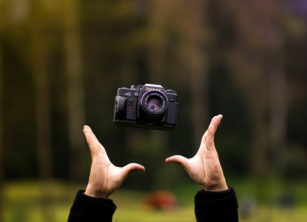 Fotografia con messa a fuoco selettiva della persona che trowing macchina fotografica del ponte nero