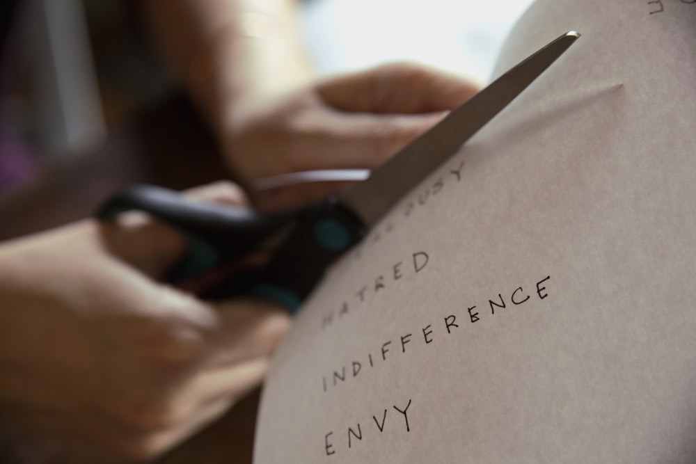 person cutting piece of paper