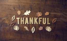 brown wooden board with letters spelling thankful