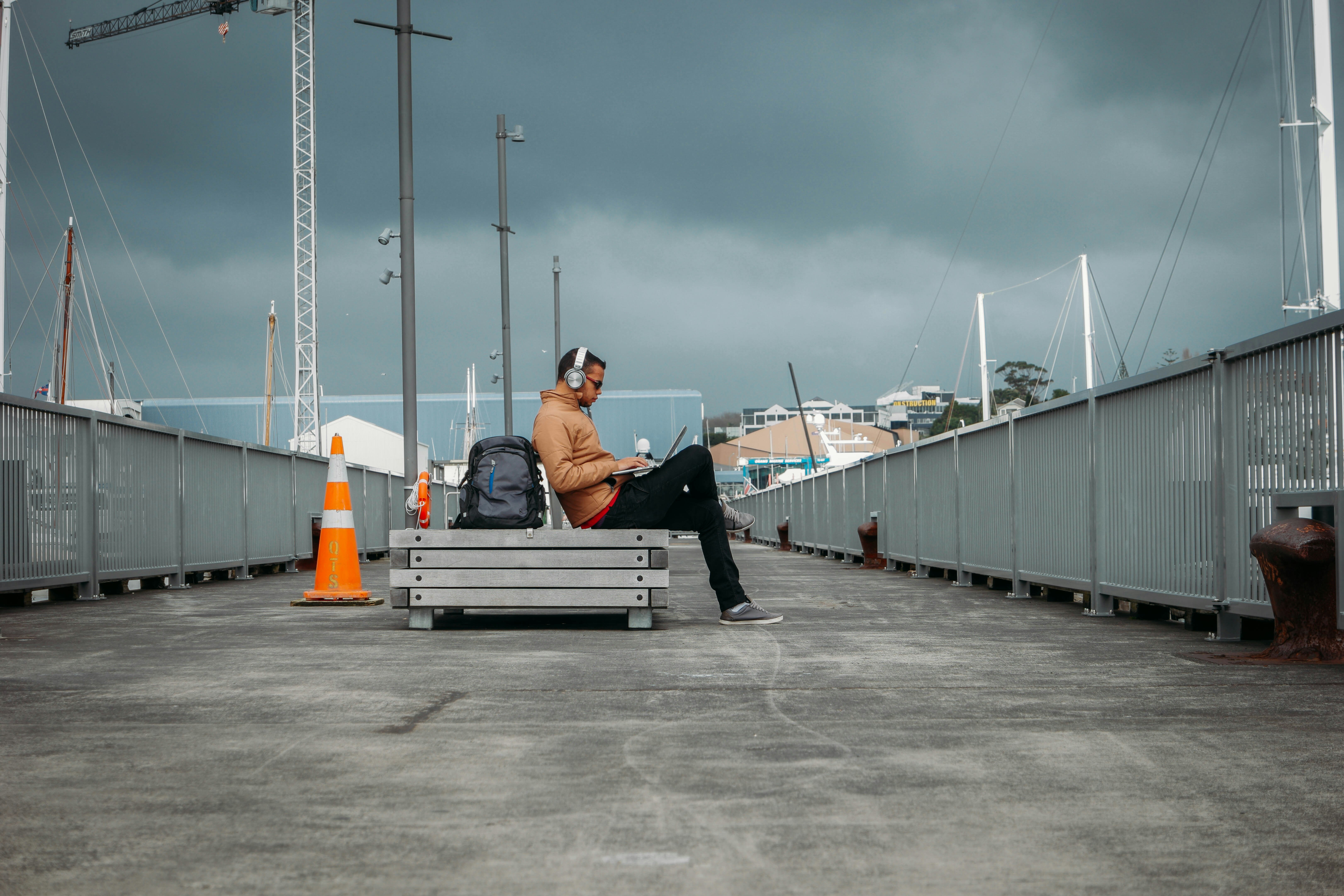 person sitting on bench wearing headphones, Digital Nomad