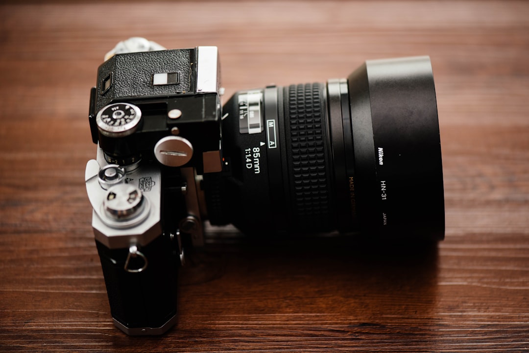 black SLR camera on brown wooden table