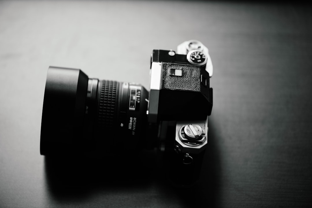 grayscale photo of SLR camera with zoom lens