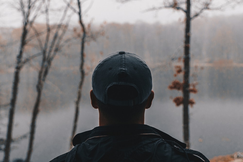 shallow focus photography of man wearing gray baseball cap