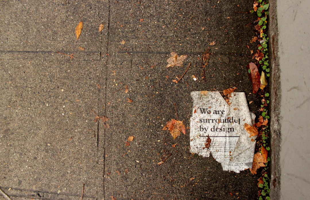 We Are Surrounded By Design Printed Newspaper On Ground Near Dried