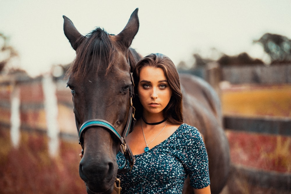 woman standing near brown horse