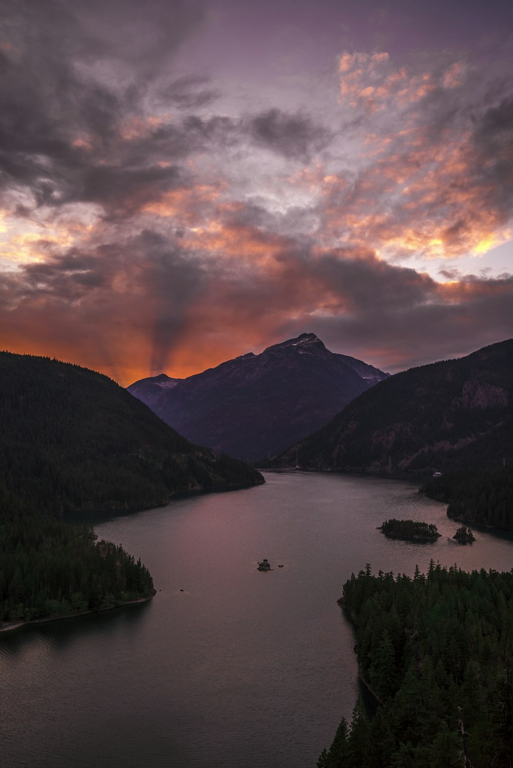 body of water surrounded by mountains during golden hour