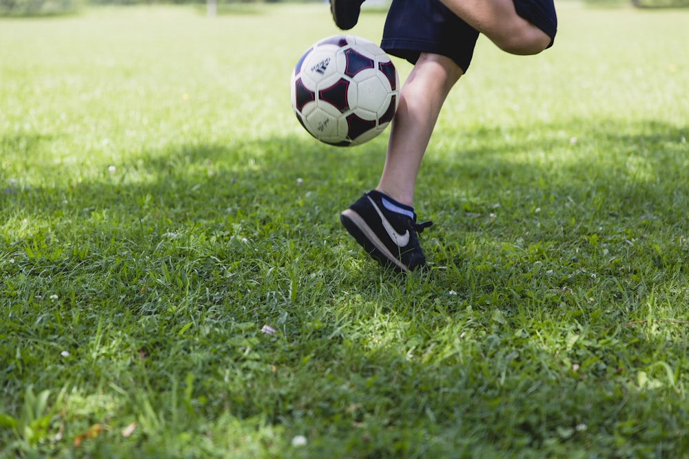 Persona que corre mientras patea la pelota