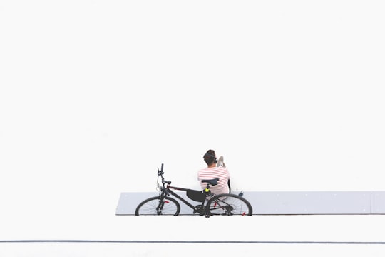 man sitting beside black mountain bike in Warsaw Poland