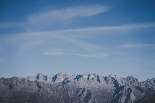 A panoramic view of Idaho's rugged mountains under a bright peacock blue sky.
