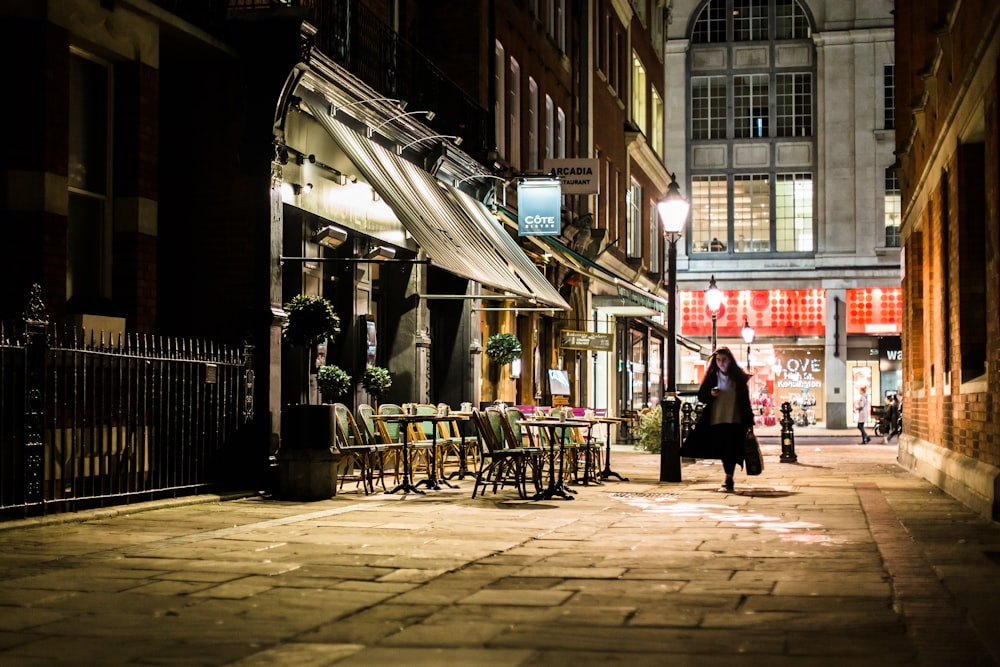 woman walking in alley near white store