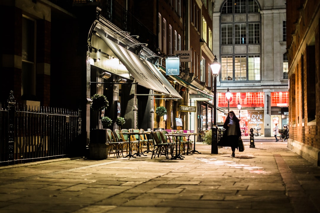 woman walking in alley near white store, Cote Bistro