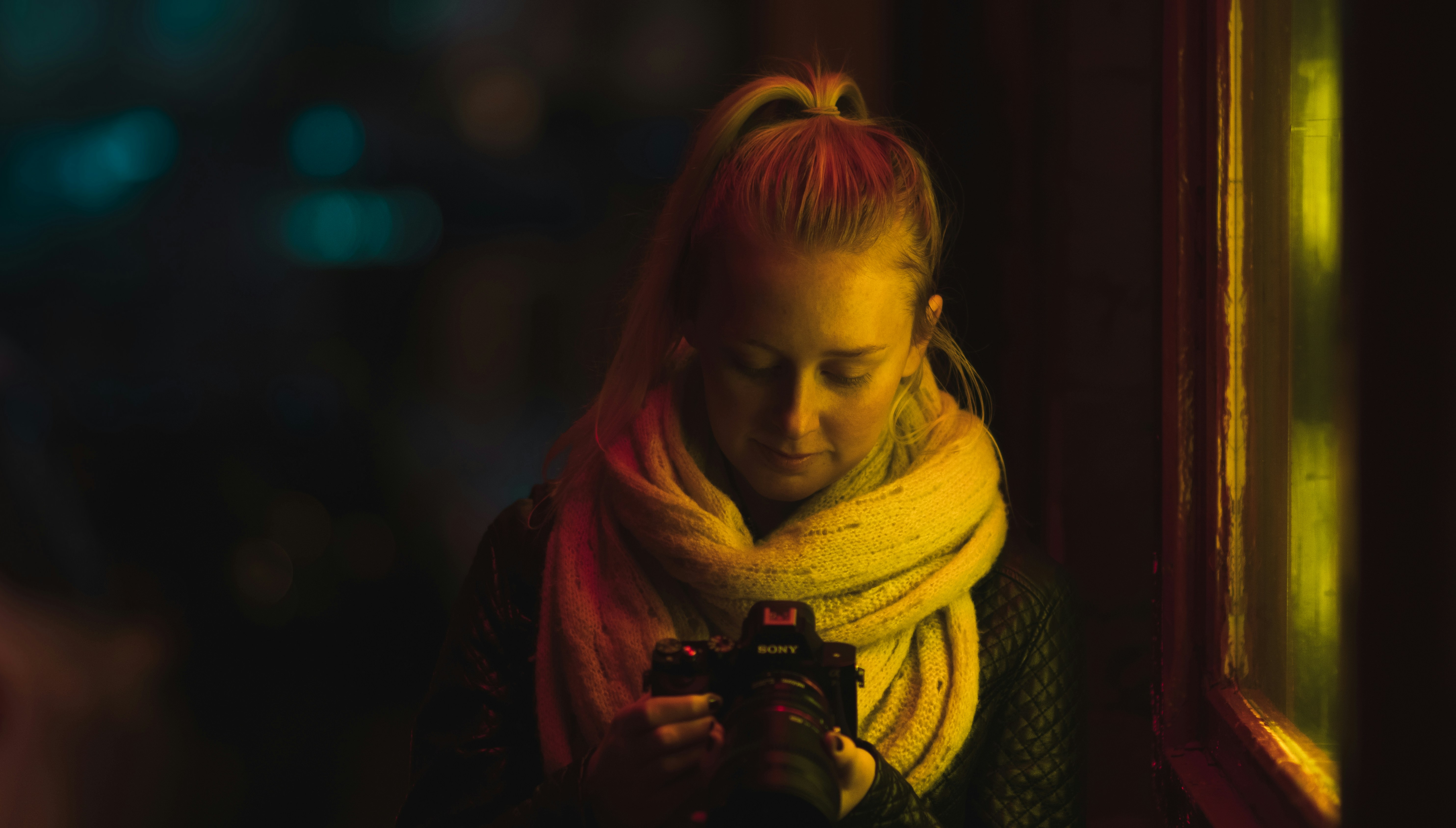 We were searching our city for different neon signs. Captured this as she stopped to check her shots in front of a window with a neon light. Love the blue tones on the left of frame contrasting the strong yellow light on the right.