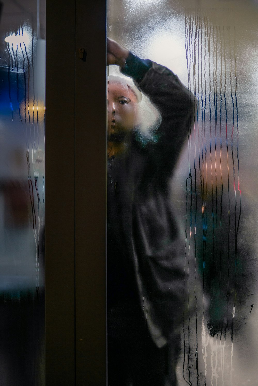 closeup photo of man standing near glass panel door