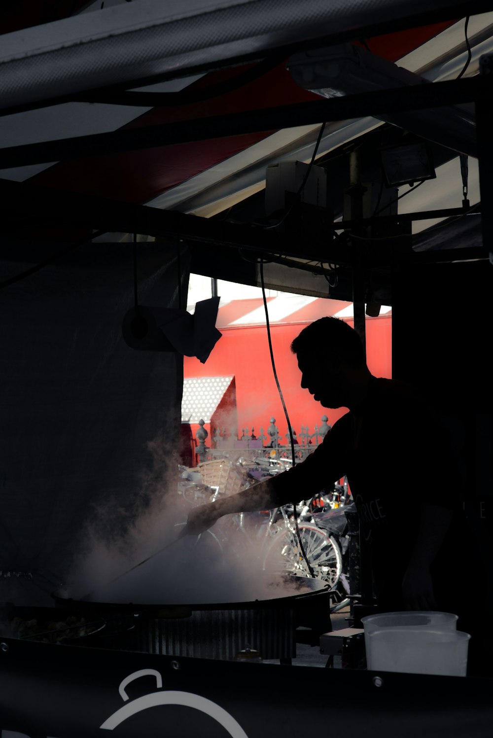 silhouette of man standing while cooking inside building