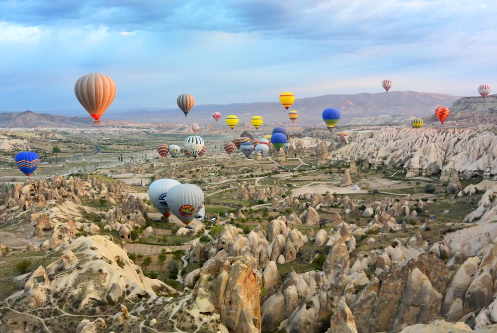日中の空中に浮かぶ色とりどりの気球の盛り合わせの写真