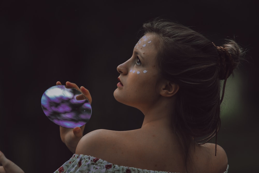 woman holding round purple and black stone