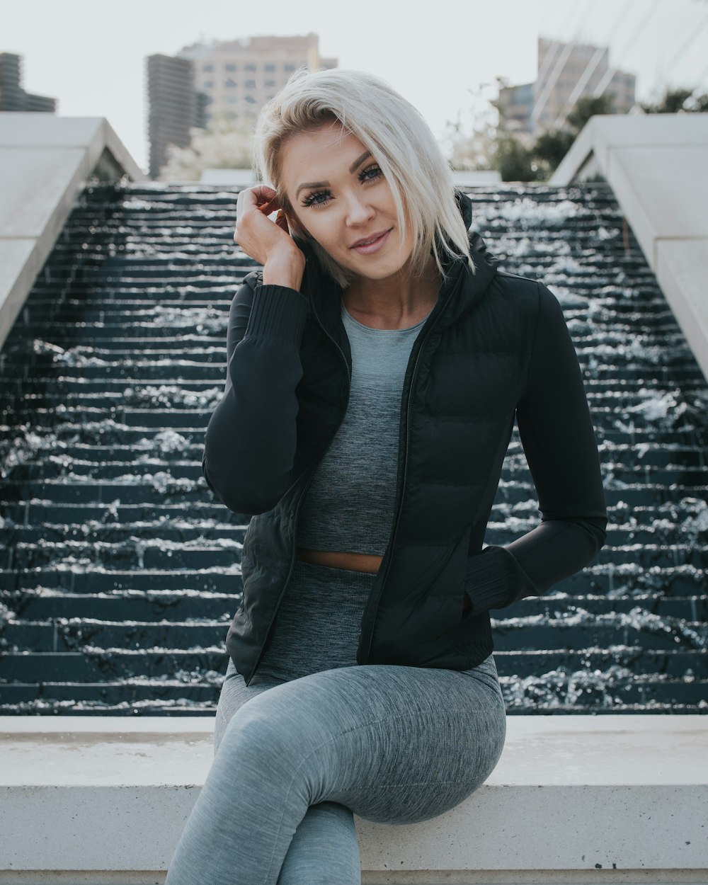 woman wearing black jacket and gray pants seating making post