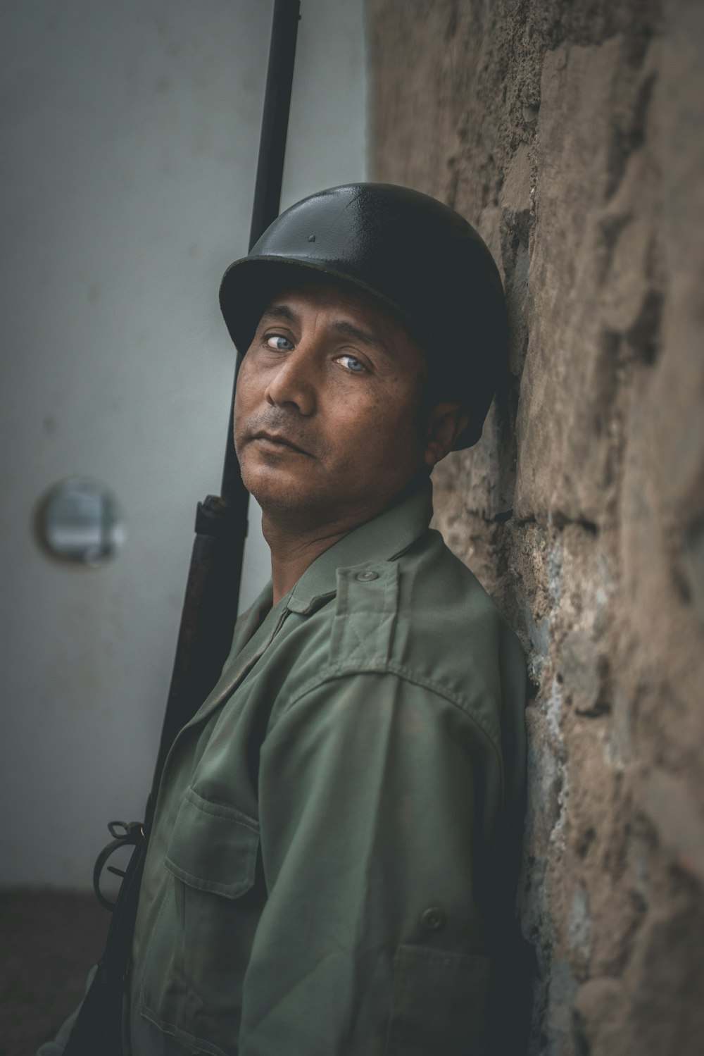 man wearing black hard hat while holding rifle