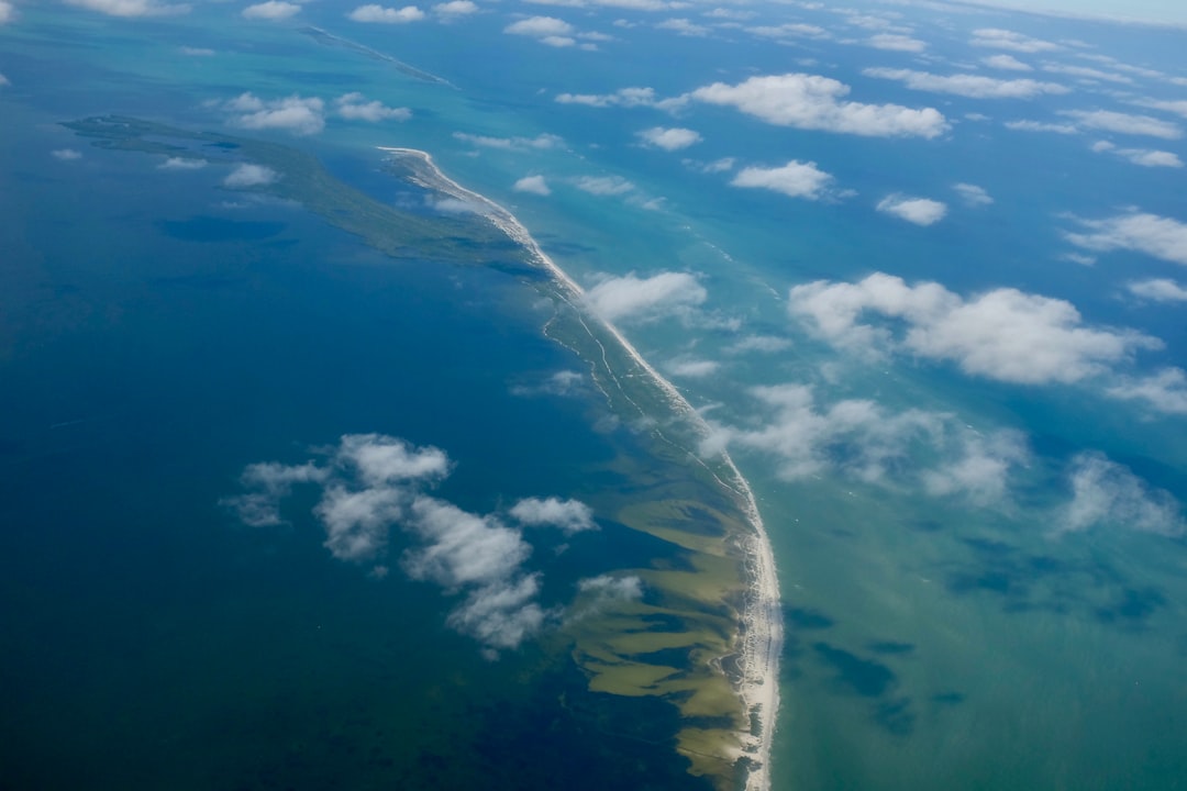 body of water under blue and white sky at daytime,
