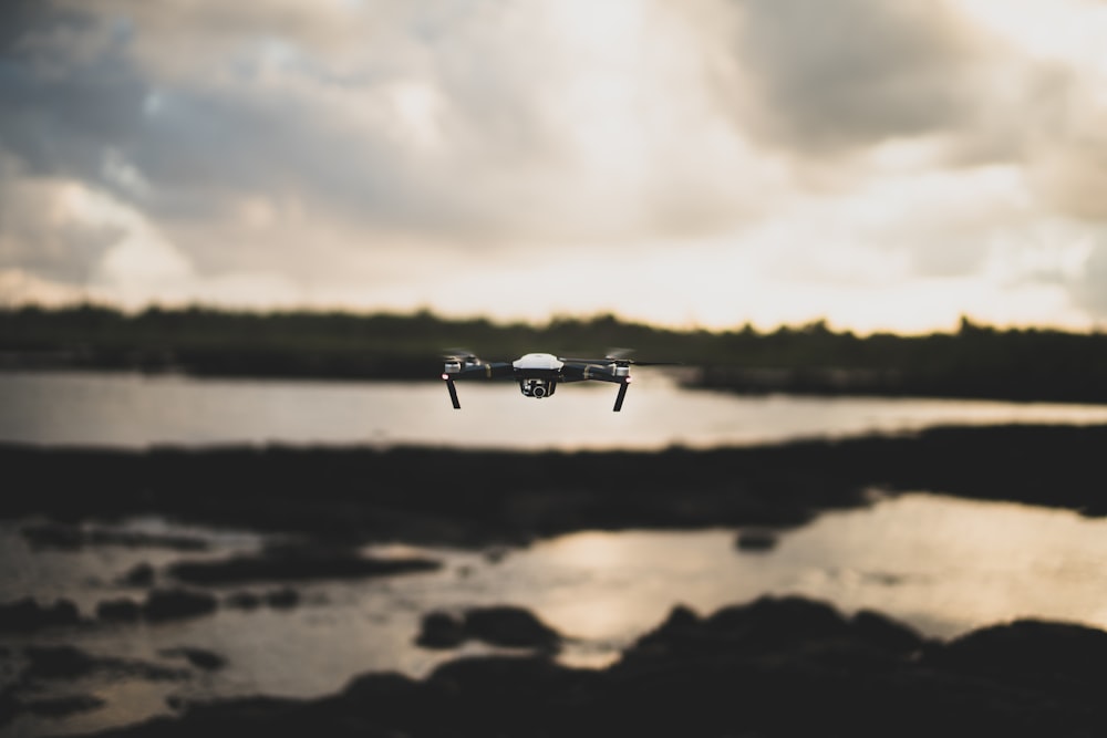 flying white and black drone during daytime
