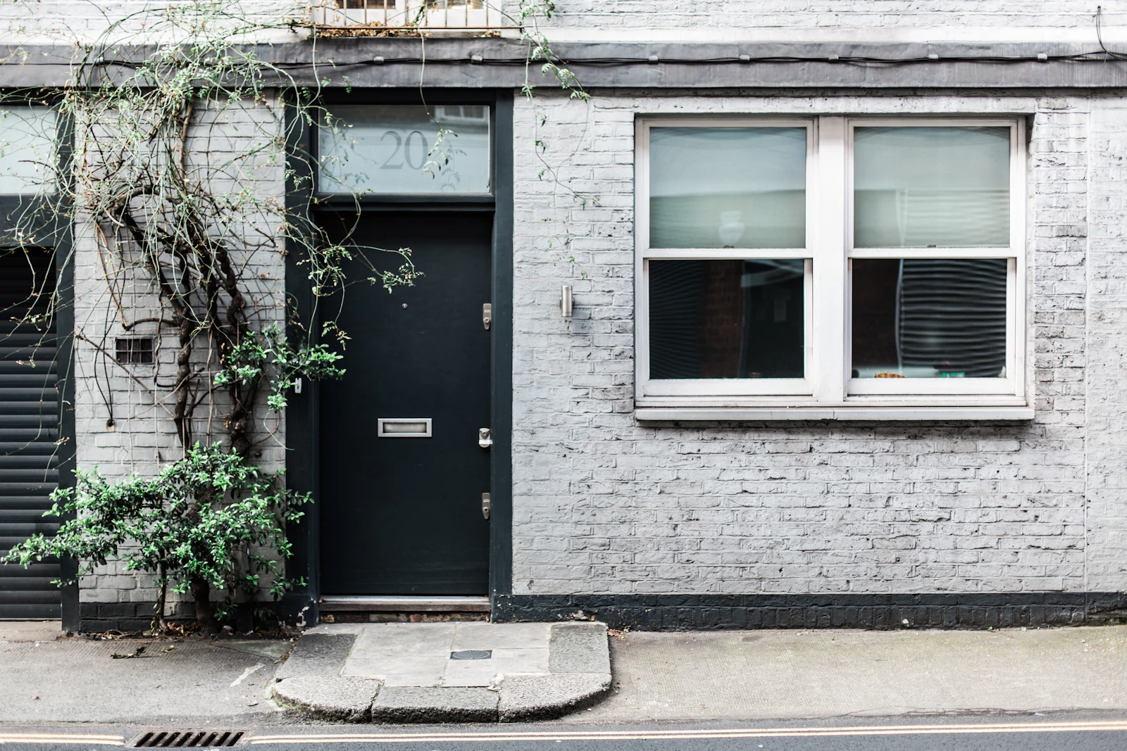 A painted brick shopfront with a black door