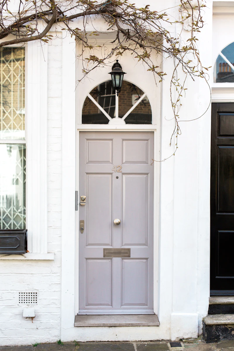 A white front door with a house number, up a short flight of steps