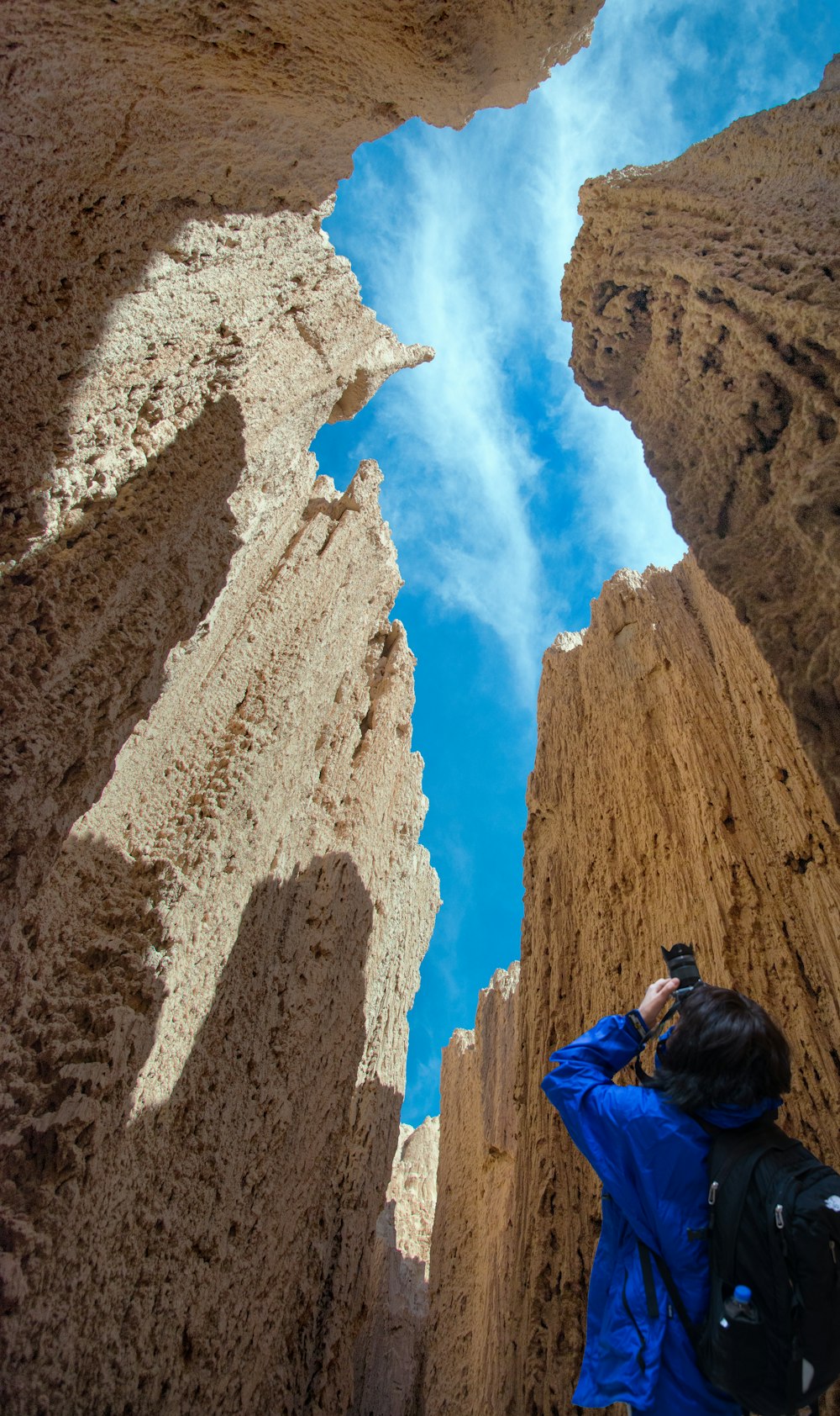 person in blue jacket capturing image of stones