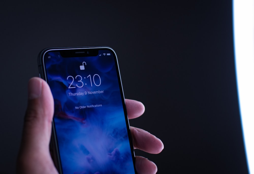 persona sosteniendo el espacio gris iPhone X