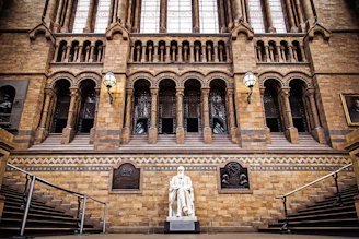 landscape photo of statue infront of brown building