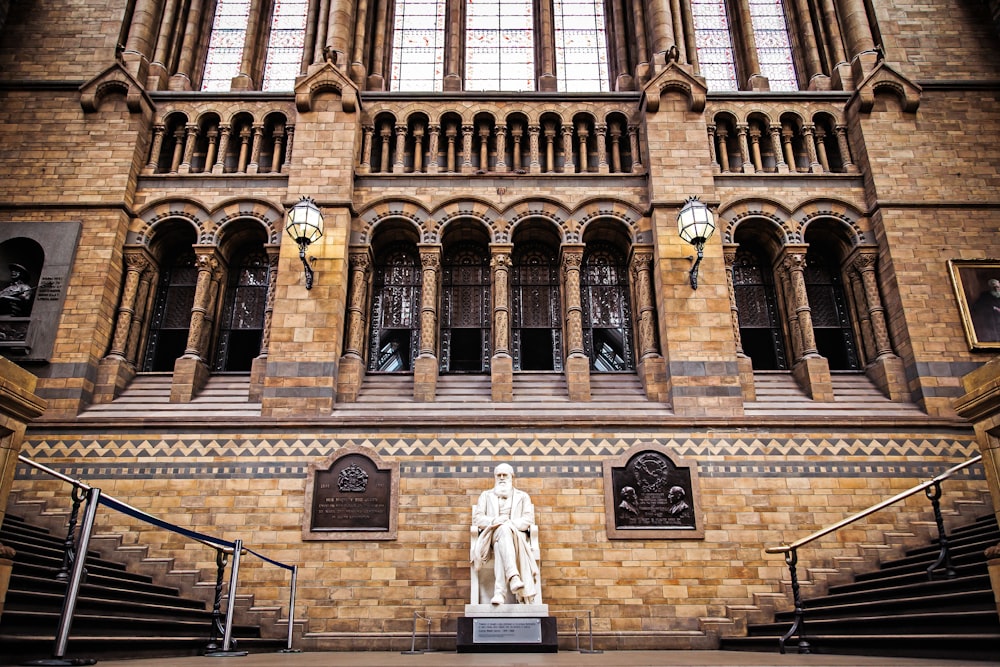 landscape photo of statue infront of brown building